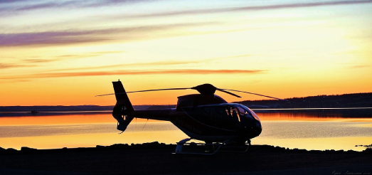 Maandunud helikopter päikeseloojangu taustal.